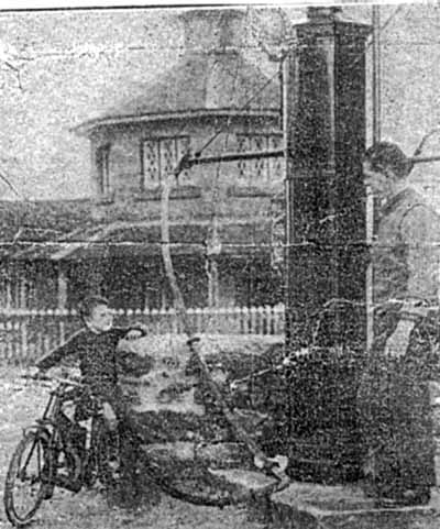 Zoom in Donald Menzies, 4 year old son of Frank, getting a fill of petrol for the miniature motor cycle