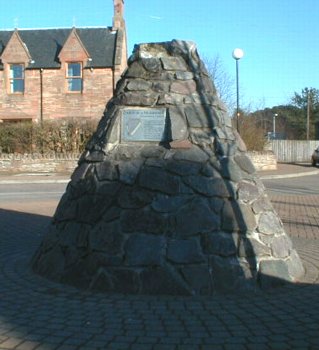 Zoom in Harper's Cairn, at the entrance to the car park in the centre of Muir of Ord.