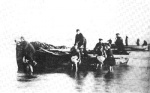 Women carrying their menfolk ashore.