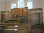 This shows the interior of the church and the impressive pulpit with the emblem of the Burning Bush.