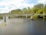 The view looking upstream showing the metal bridge carrying utility pipes between Maryburgh and Conon and the railway bridge behind.