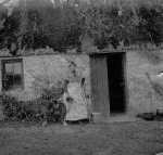 Donnie Mackenzie's house when thatched (1915). Donnie's granny at the door.